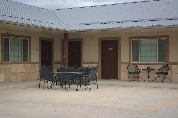 A photo of tables and chairs outside a motel